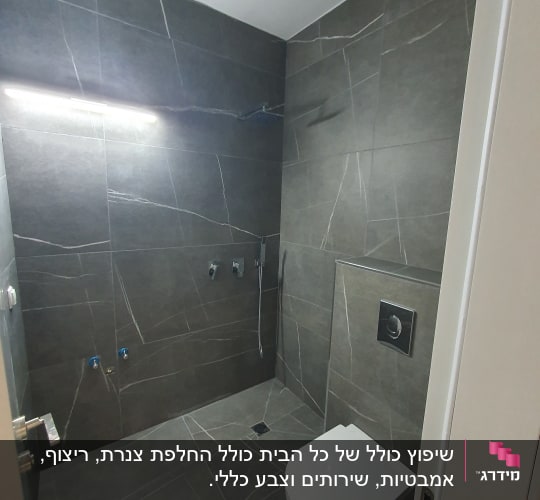 חדר אמבטיה עם קירות ורצפה מאבן כהה, אסלה תלויה